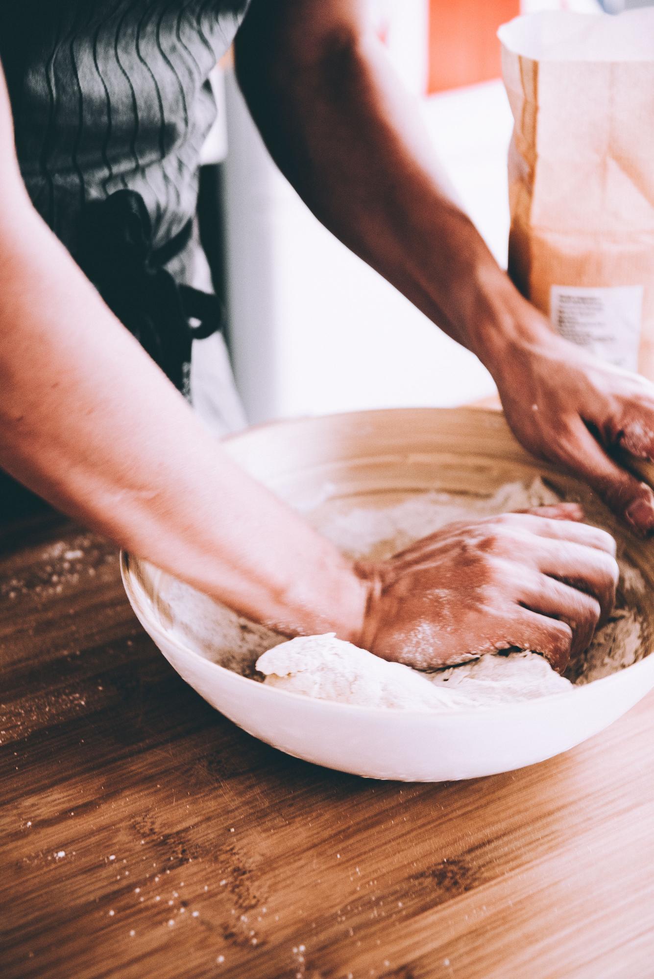 Hands kneading dough in warm kitchen light